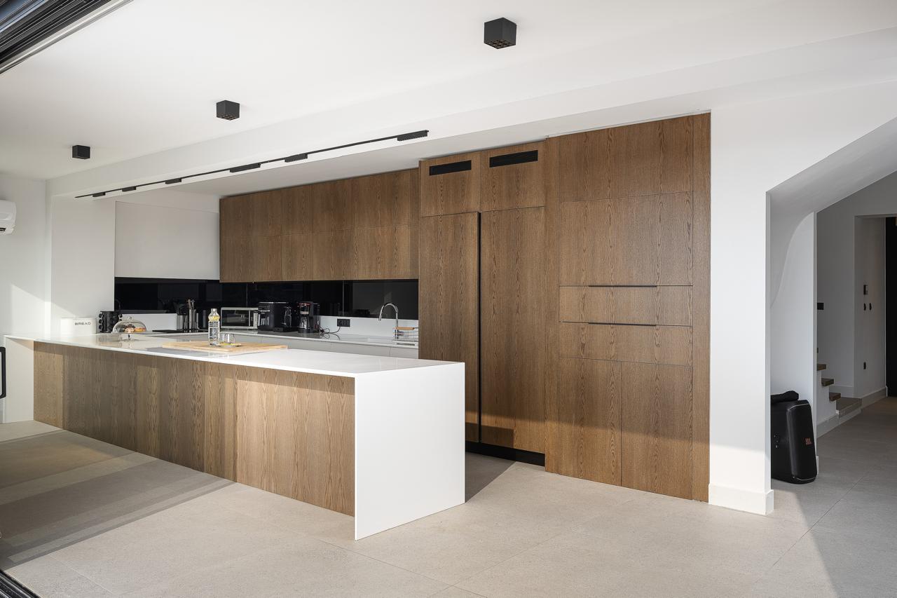 Oak joinery wall and white stone island