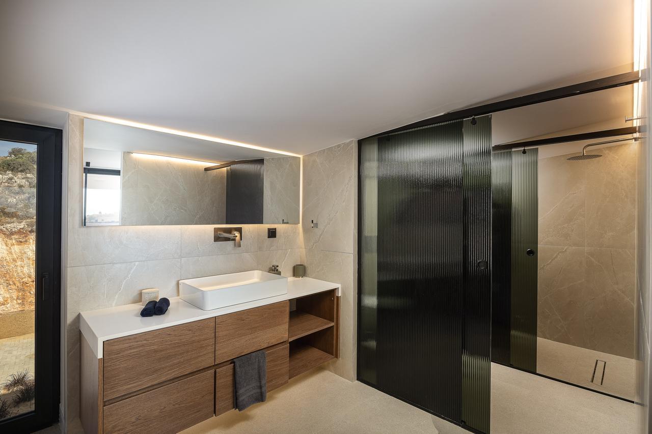 Ensuite with stone vanity and fluted glass shower screen