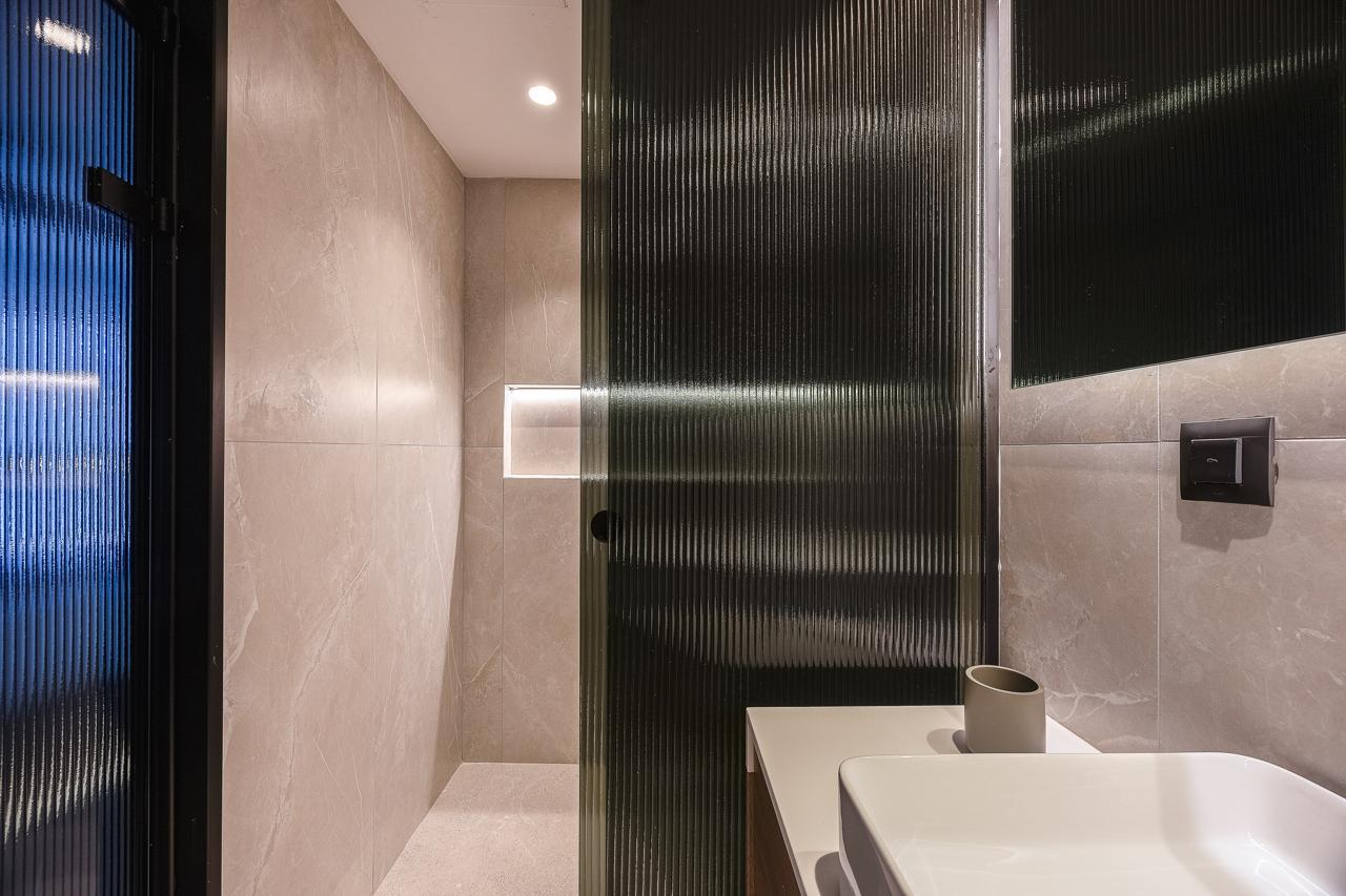 Walk-in shower behind fluted glass