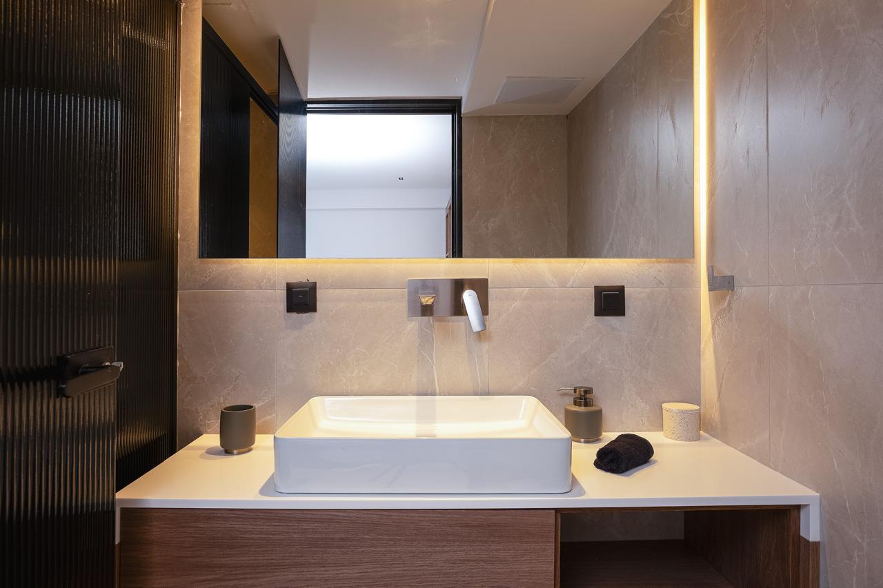 Backlit mirror above the stone vanity