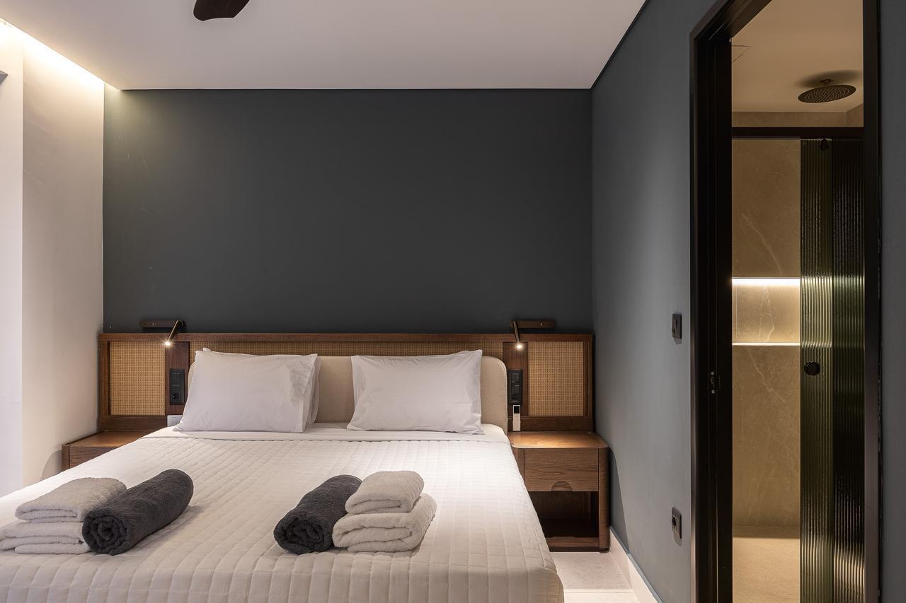 Cane headboard against the deep charcoal wall